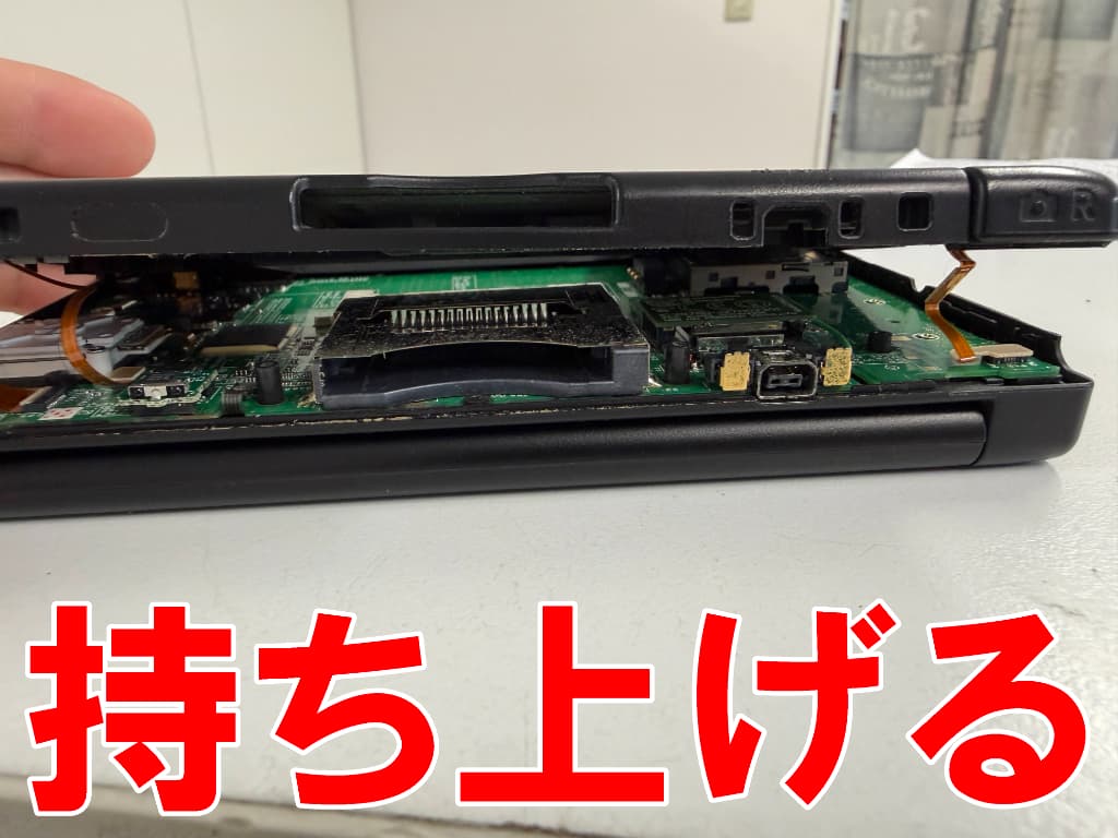 外装部分を持ち上げているAボタン交換中のニンテンドー3DSLL