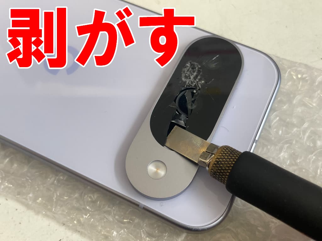 割れたメインカメラレンズを剥がしているPixel10
