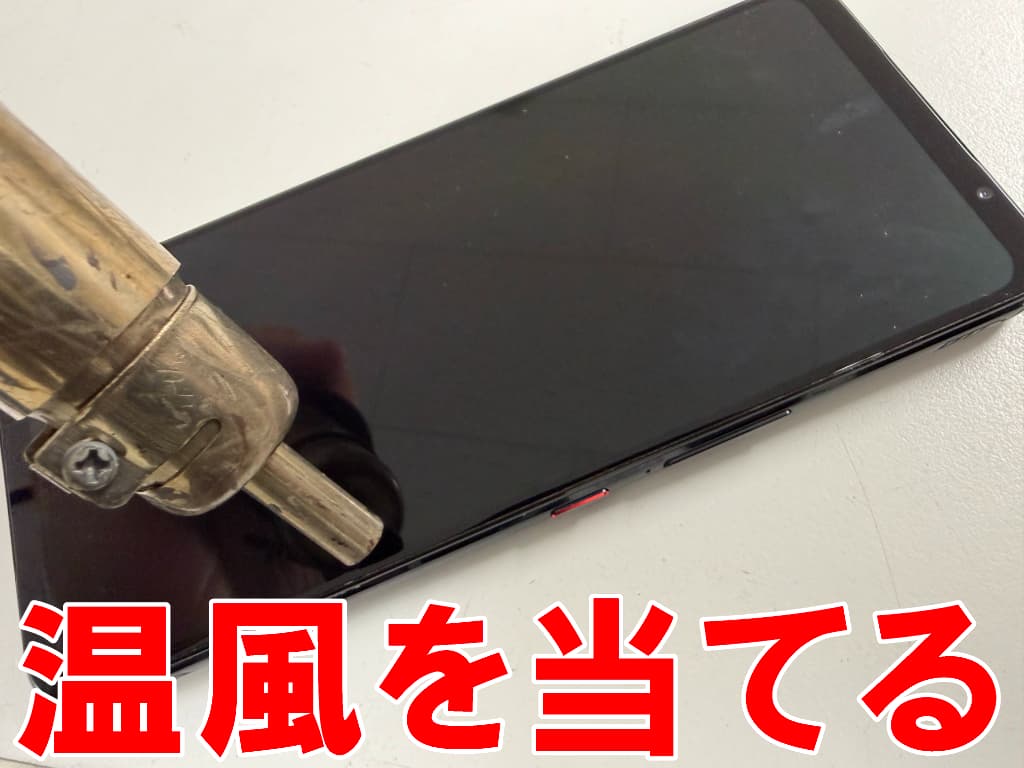 故障したフロントパネルに温風を当てているROG Phone7