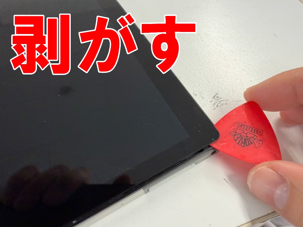 液晶画面と本体フレームとの粘着を剥がしている充電口交換中のZ会タブレット(第二世代)