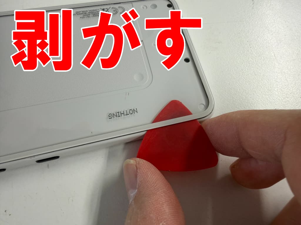 背面パネルと本体フレームとの粘着を剥がしている画面修理中のPhone (3a) Lite