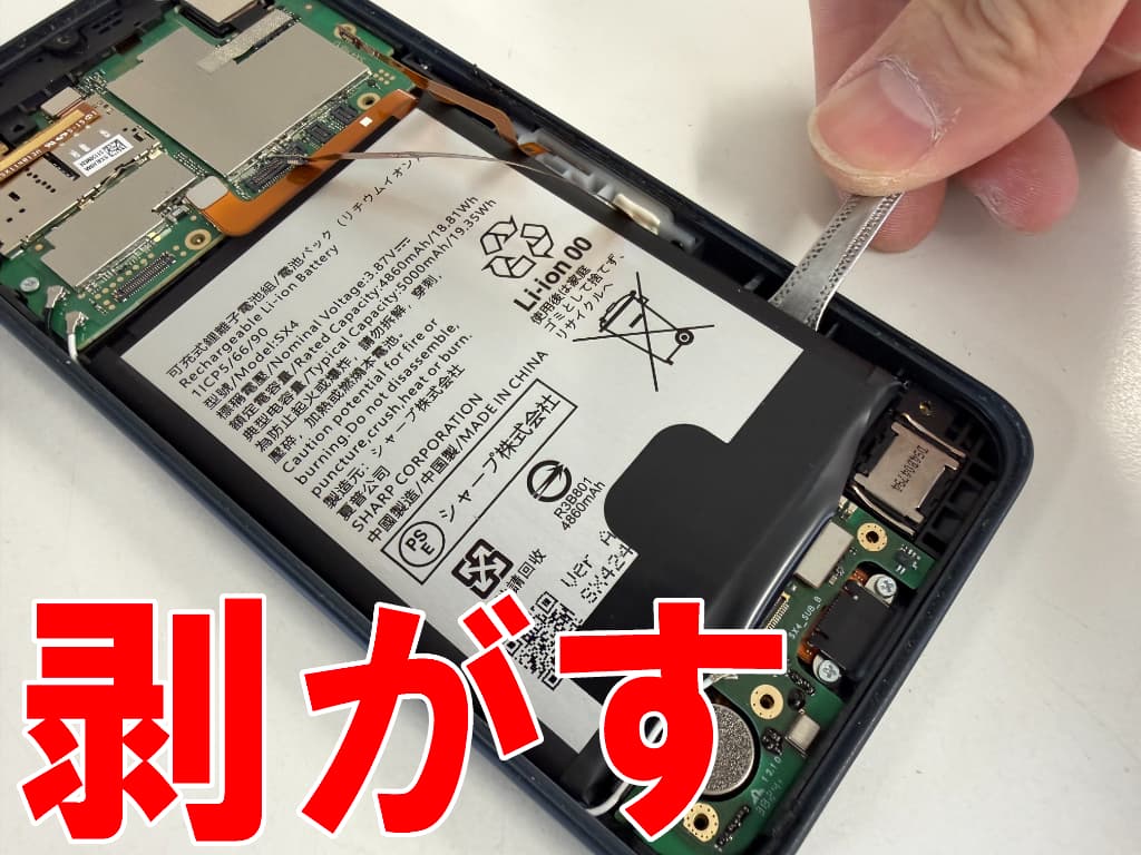 バッテリーを固定している粘着を剥がしているAQUOS wish4