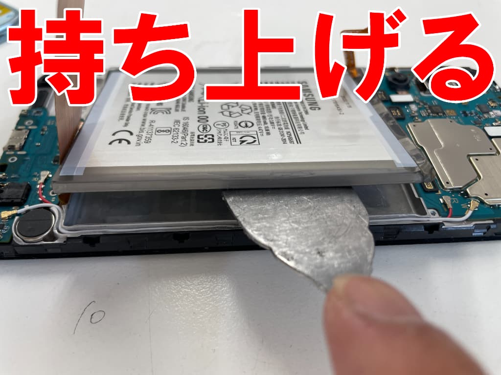 本体フレームから劣化したバッテリーを取り出しているGalaxy M23 5G