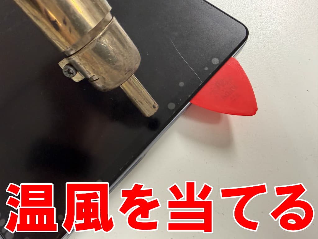 フロントパネルに温風を当てている充電部分修理中のLenovoTab Plus