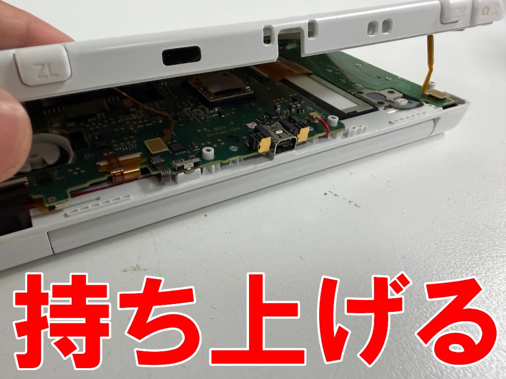 外装を持ち上げたスライドパッドのラッチ修理中のNew 3DS LL