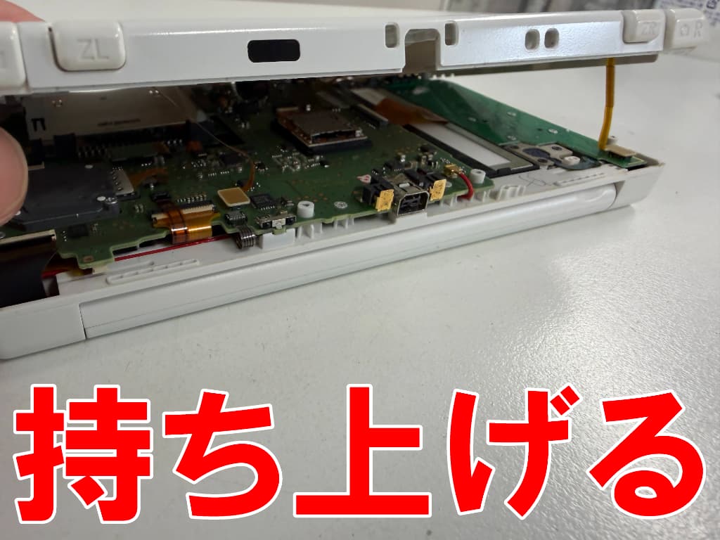 本体フレームを持ち上げているAボタン修理中のNew ニンテンドー3DS LL
