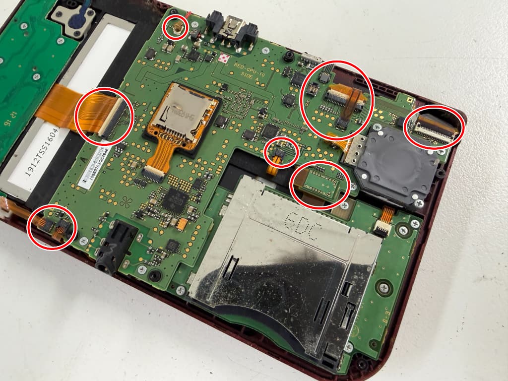 基板に無数のケーブルが接続されている下側画面交換修理中のニンテンドーNew 3DSLL