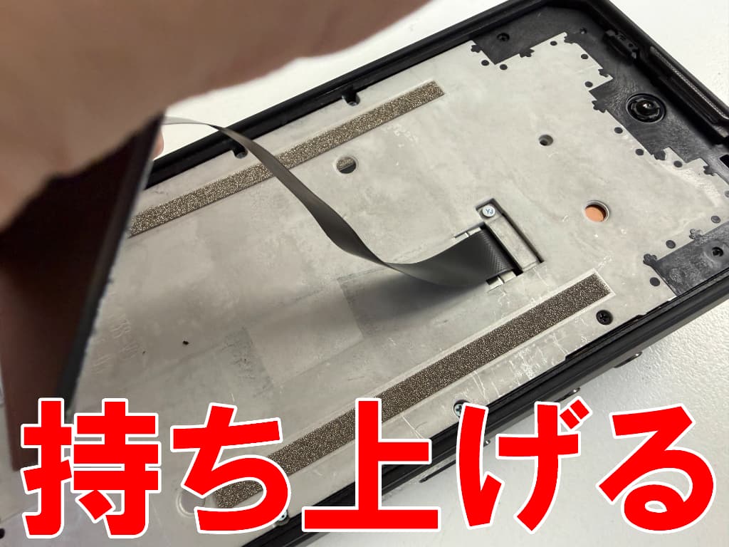 液晶画面を持ち上げて本体フレームから剥がしているOUKITEL WP56