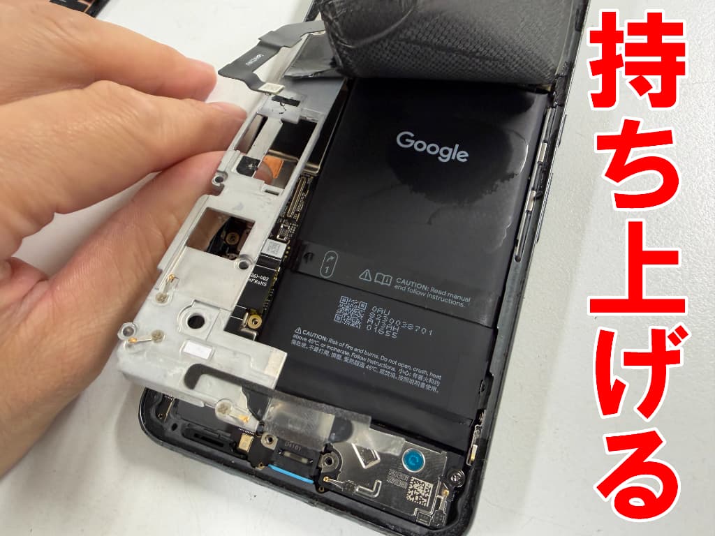 基板を覆った銀板を持ち上げた電池交換中のPixel8Pro