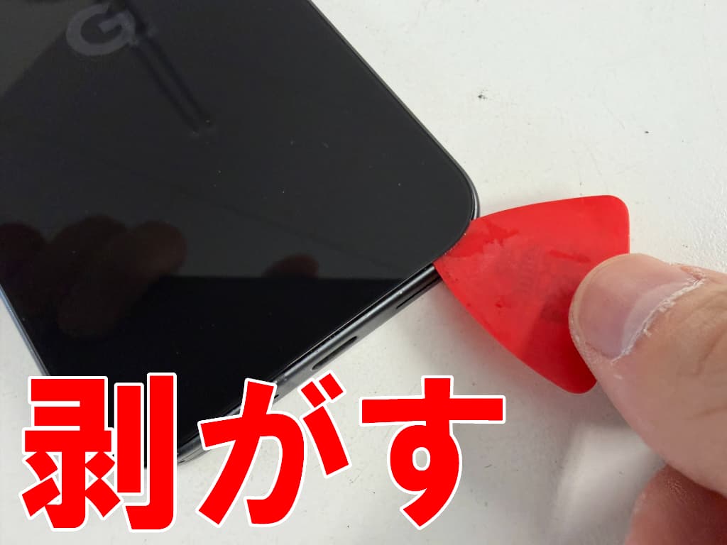 背面パネルの粘着を剥がしている水没修理中のPixel9