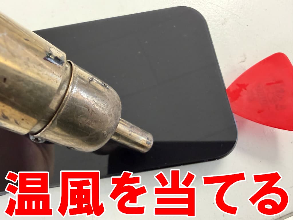 バックパネルに温風を当てている水濡れ修理中のPixel9