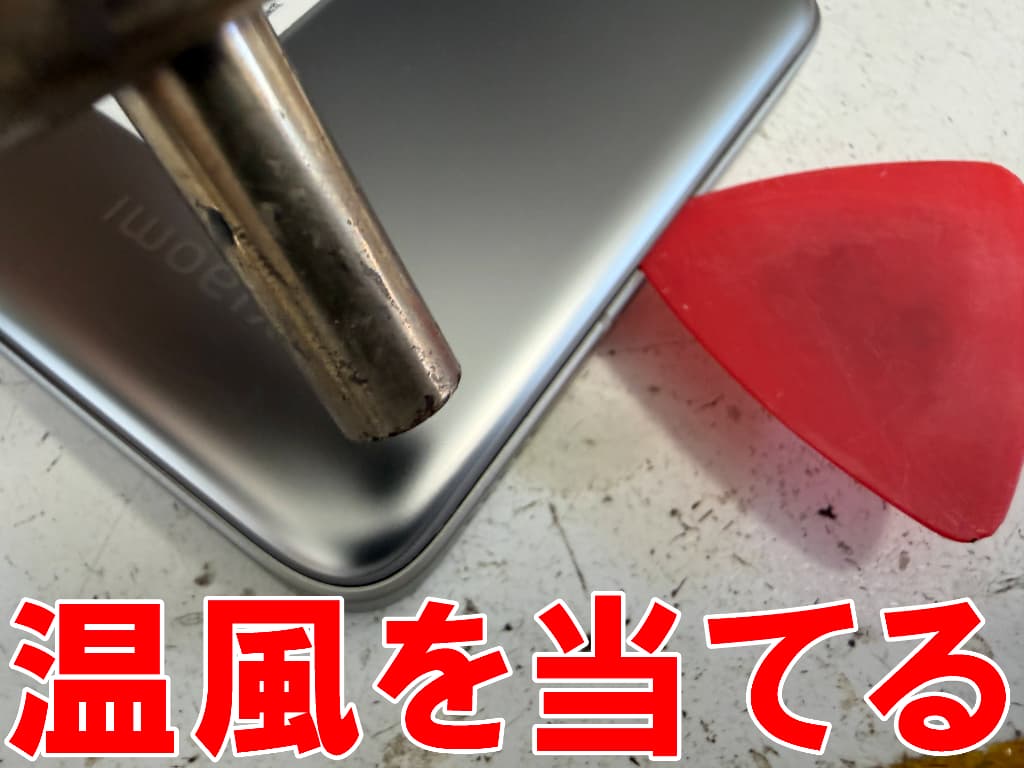 バックパネルに温風を当てているリチウムイオンバッテリー交換中のXiaomi14TPro