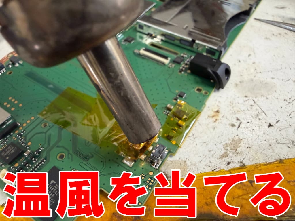 新しい電源ボタンパーツを基板にはんだ付けしている2DSLL