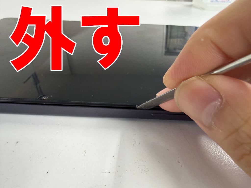 背面パネルと本体フレームとの粘着を剥がしているスリープボタン修理中のDOOGEE A9+