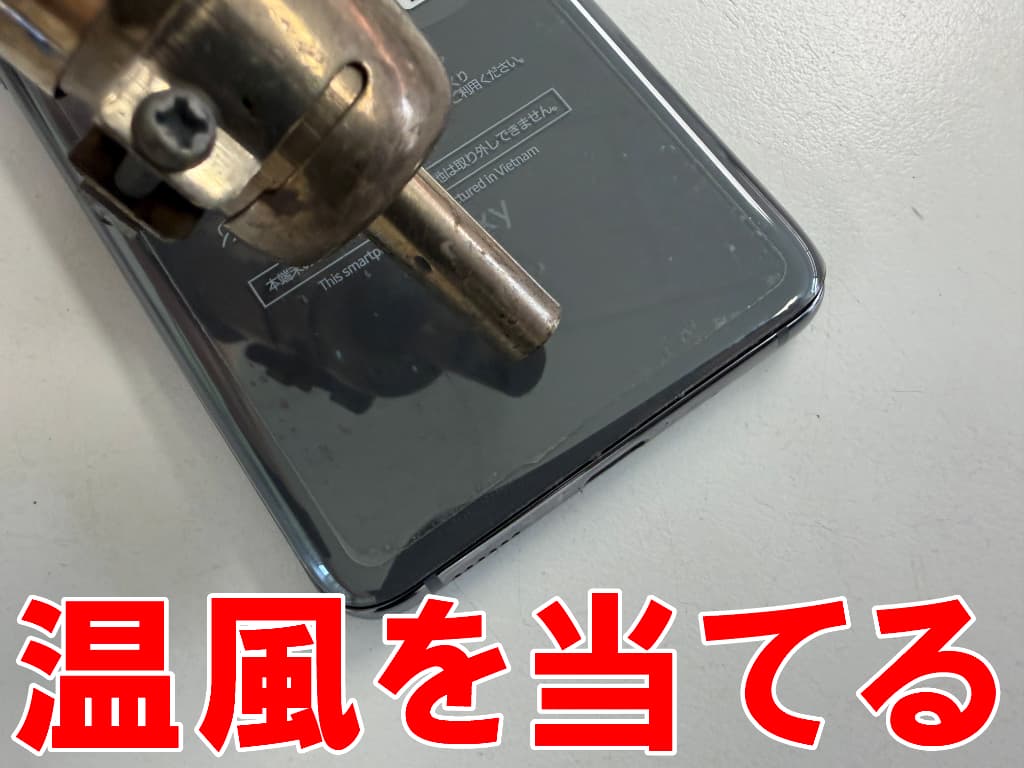 背面パネルに温風を当てているスリープボタン修理中のGalaxy S20