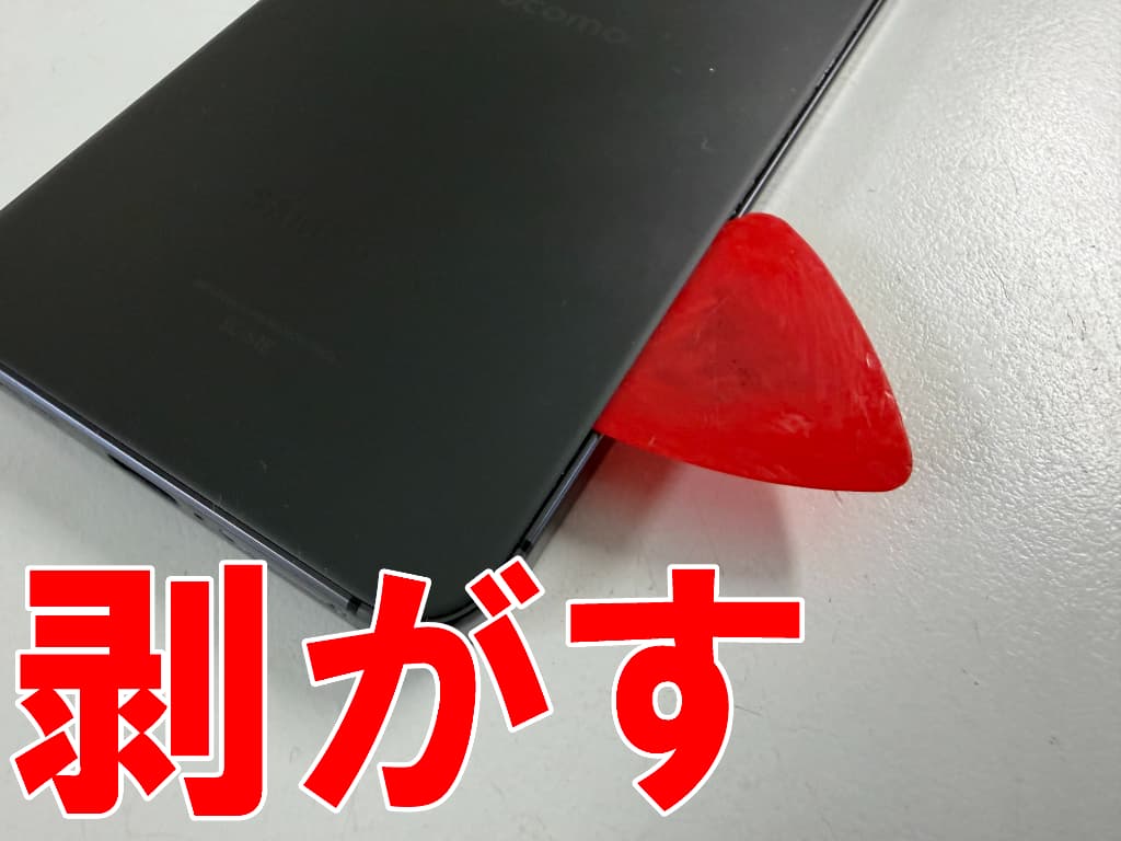 浮いた背面パネルを剥がしている電池交換中のSAMSUNG GalaxyS24
