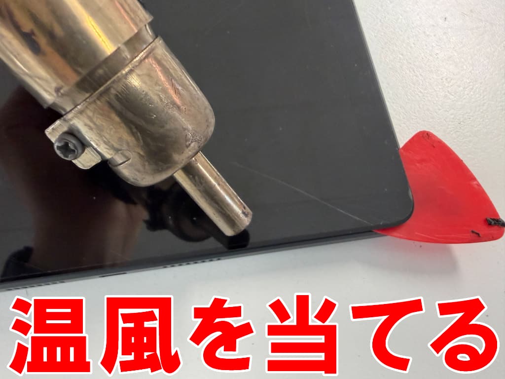 液晶画面に温風当てて粘着を弱めている充電器差し込み口交換修理中のiPlay70E