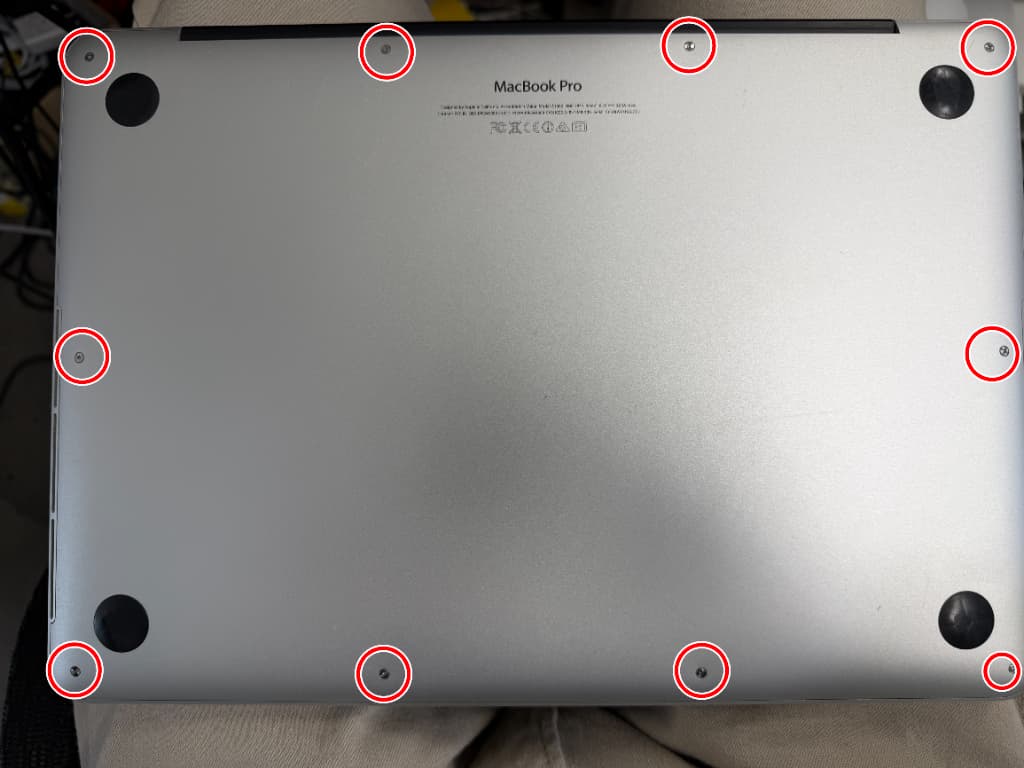 背面パネルのネジを外そうとしている電池交換修理中のMacBookPro(13inch 2015)
