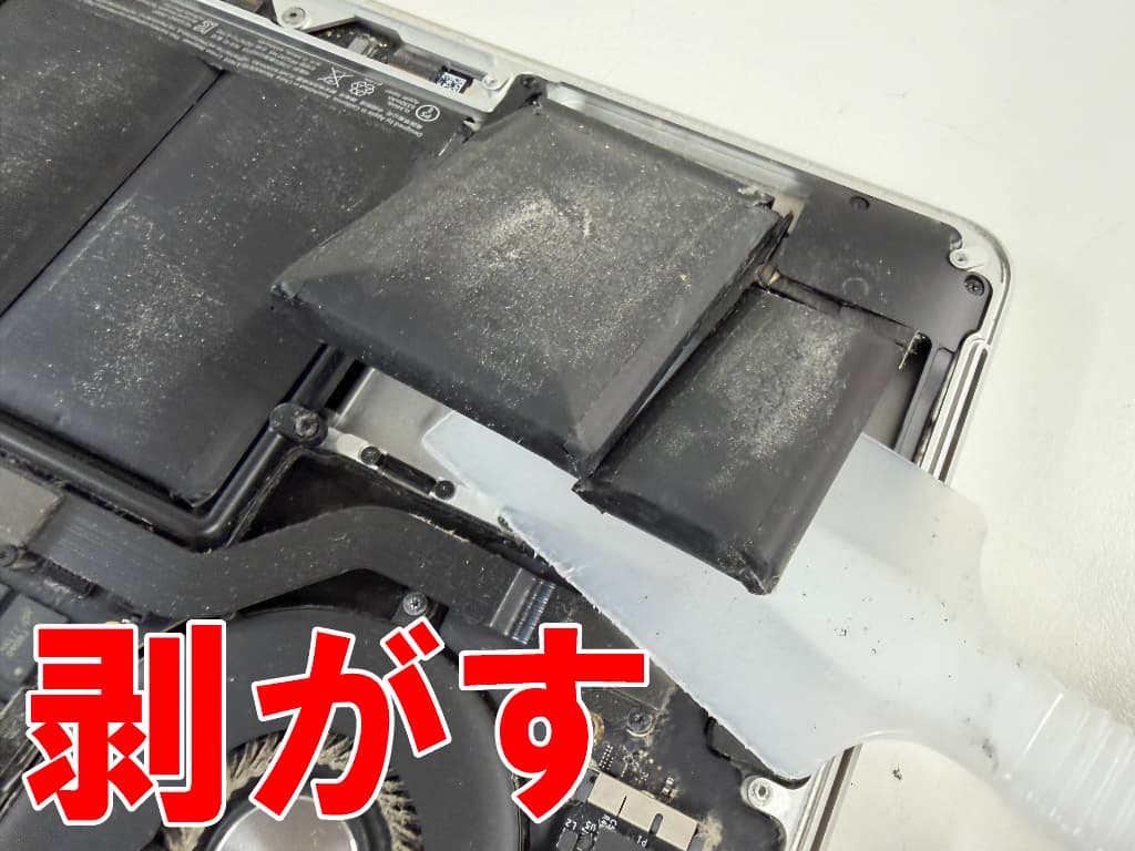劣化して膨張したリチウムイオンバッテリーを本体フレームから剥がしているマックブックプロ(13inch 2015)