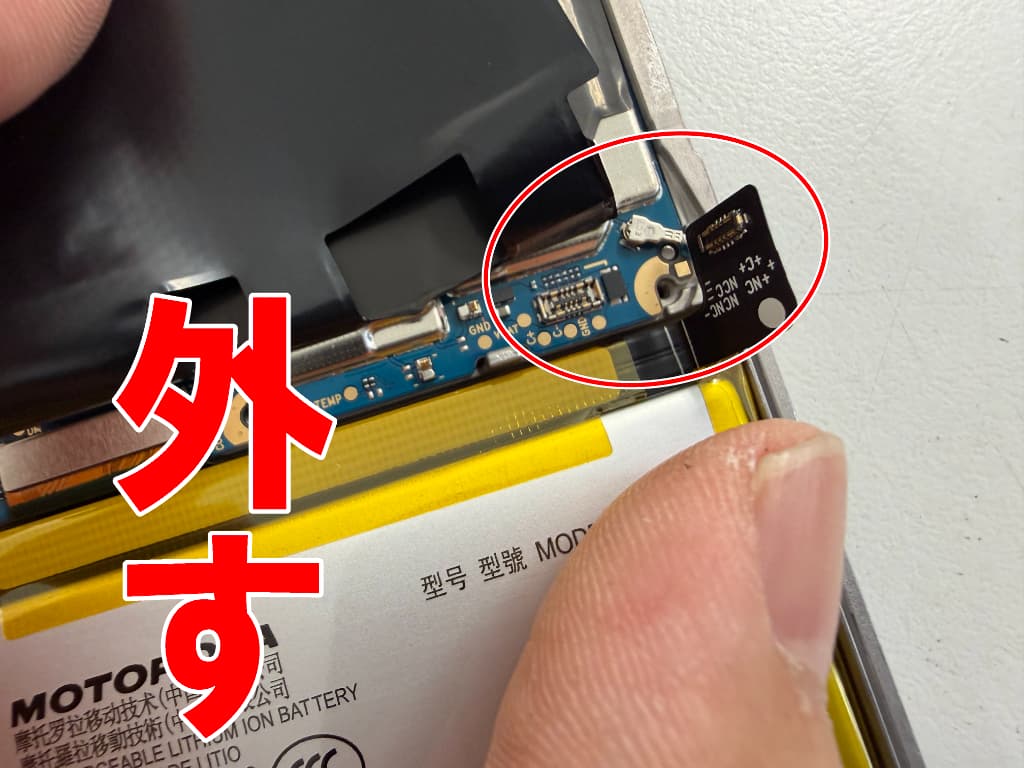 基板からバッテリーコネクタを外した電池パック交換中のmoto g24