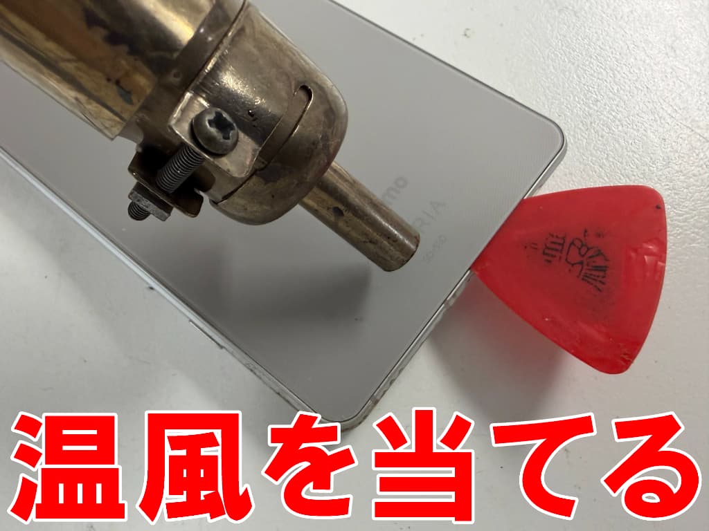 背面パネルに温風を当てている電池交換修理中のXperia1v