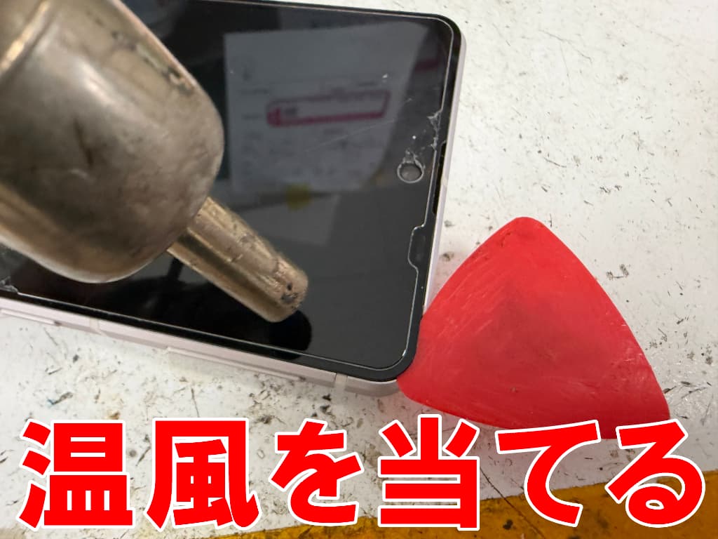 画面に温風を当てている分解中の水没したAQUOS sense7