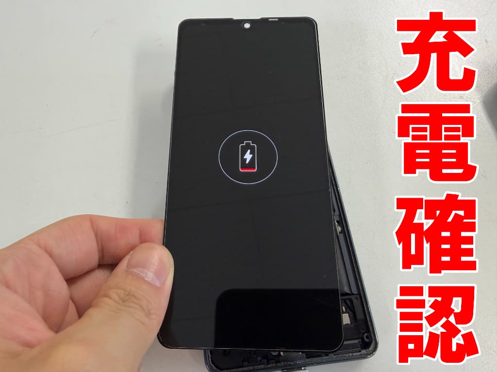 新品の充電口パーツで充電確認を行っているAQUOS sense8