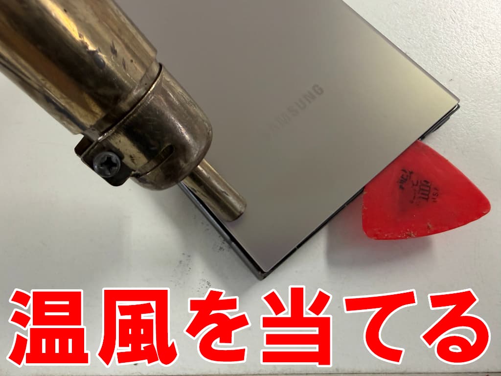 背面パネルに温風を当てている外カメラ交換修理中のGalaxy S24 Ultra
