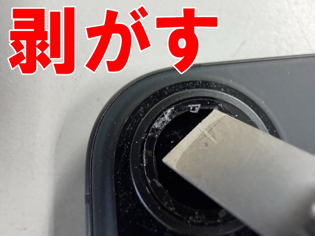 破損したメインカメラレンズを本体フレームから剥がしているiPhone16