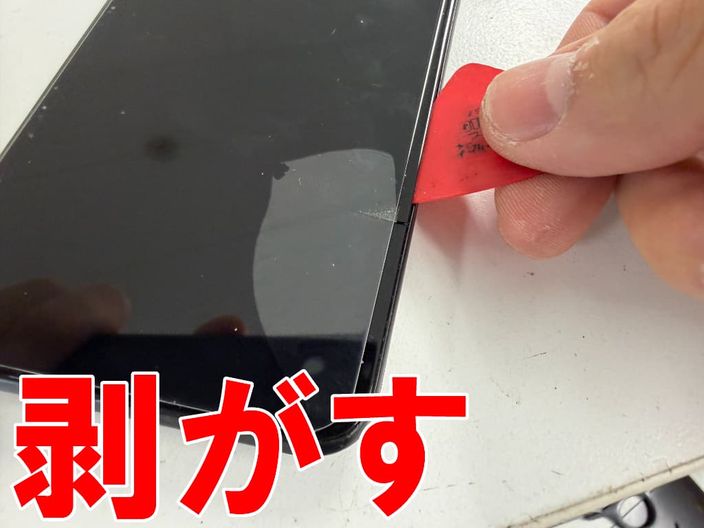 破損した画面パーツを本体フレームから取り出しているmoto g13
