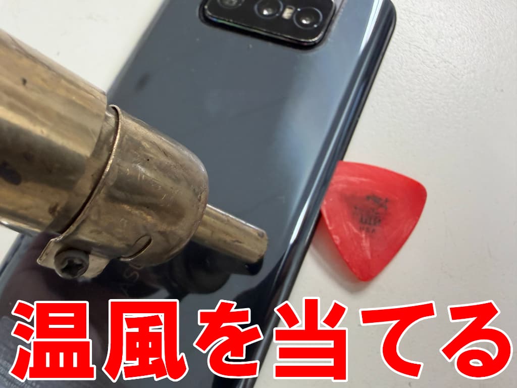バックパネルに温風を当てているバッテリー交換修理中のZenfone 8 Flip