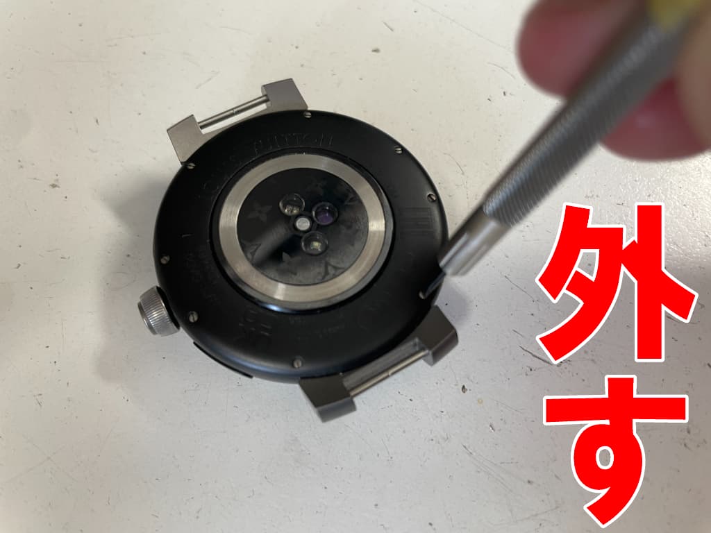 背面パネルの固定したネジを外している電池パック交換修理中のタンブールホライゾン ライト・アップ