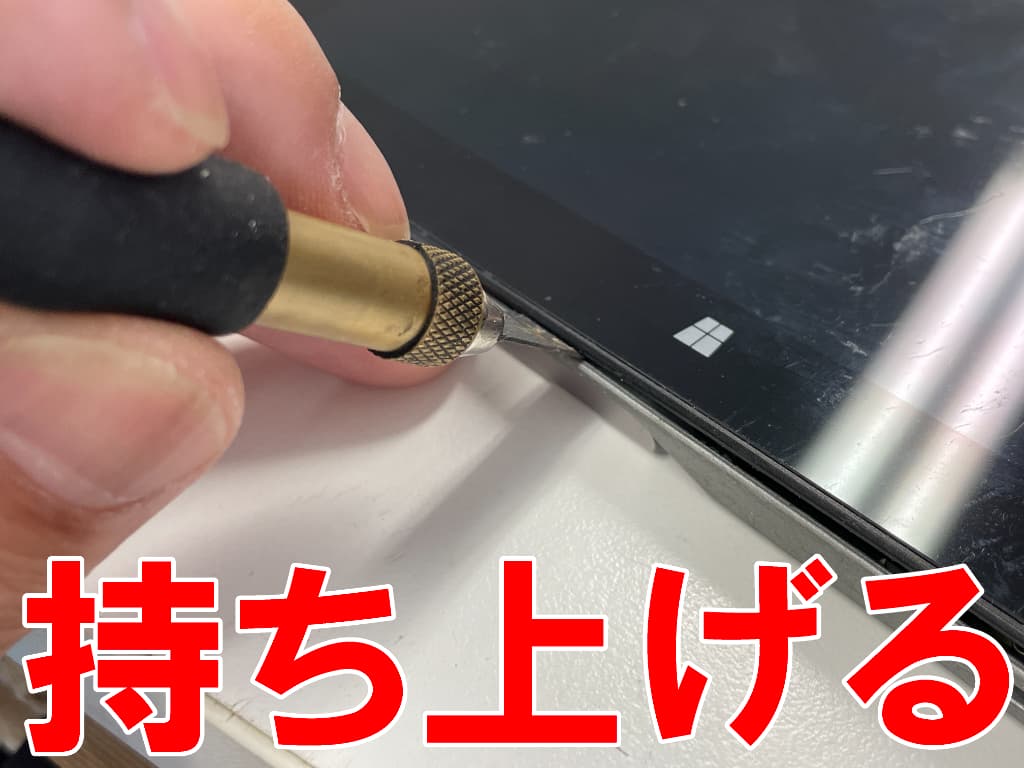 画面と本体フレームとのツメを外しているCHUWI CWI535