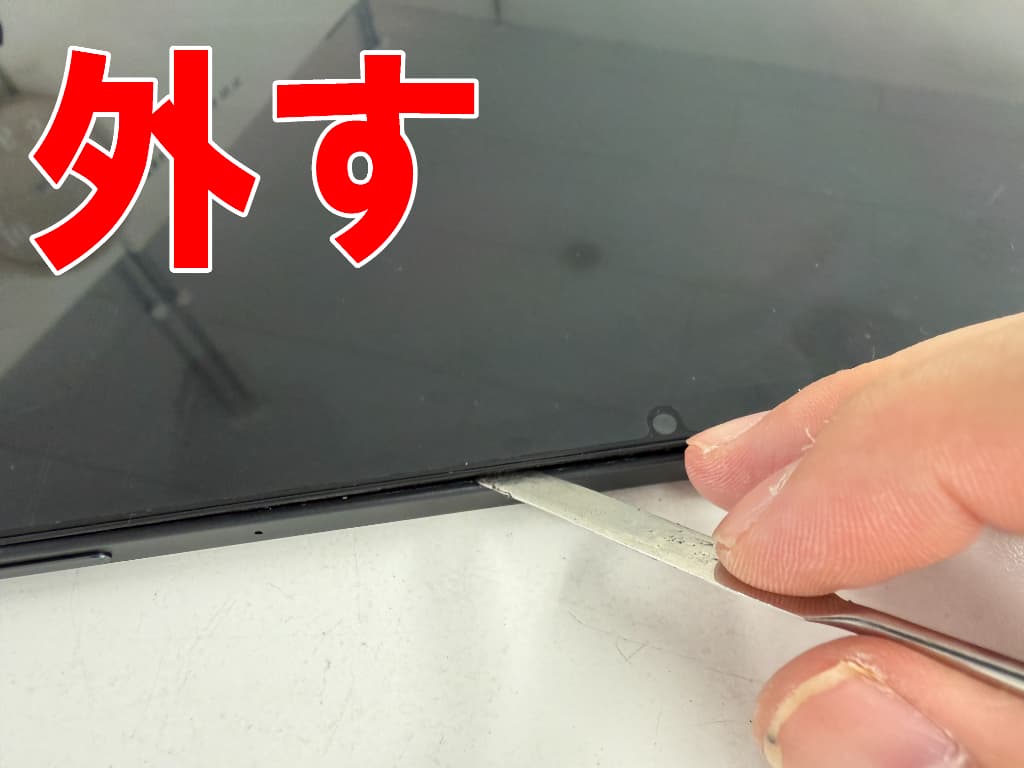 画面と本体フレームとの粘着を剥がしている充電器差し込み口交換修理中のFEONAL D136
