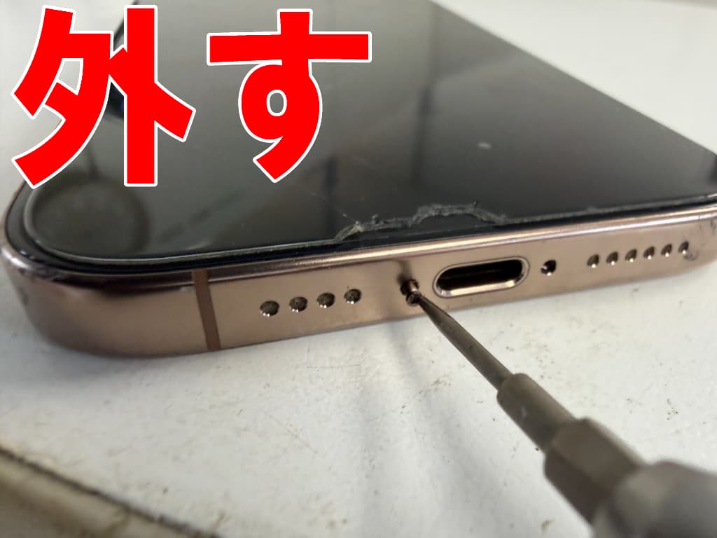 本体下部の星ネジを外している充電部分修理中のiPhone16 Pro Max