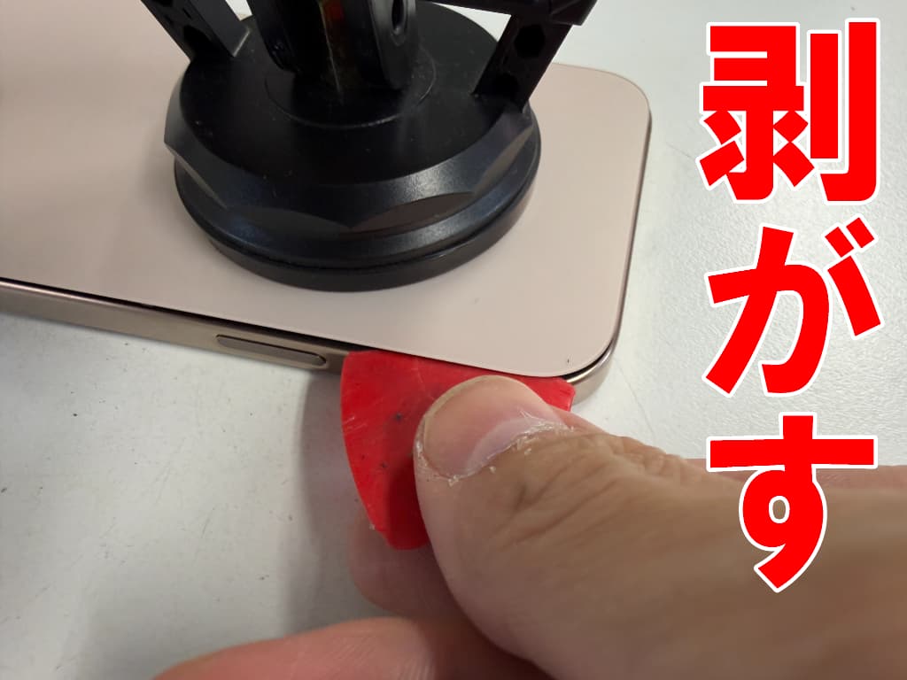 背面パネルを剥がしている充電器差し込み口交換修理中のiPhone 16 Pro Max