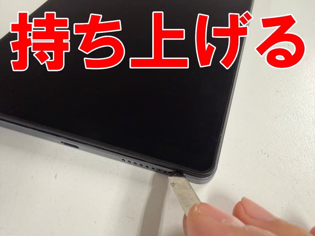 画面パーツを持ち上げている電池パック交換修理中のHeadwolf Titan1