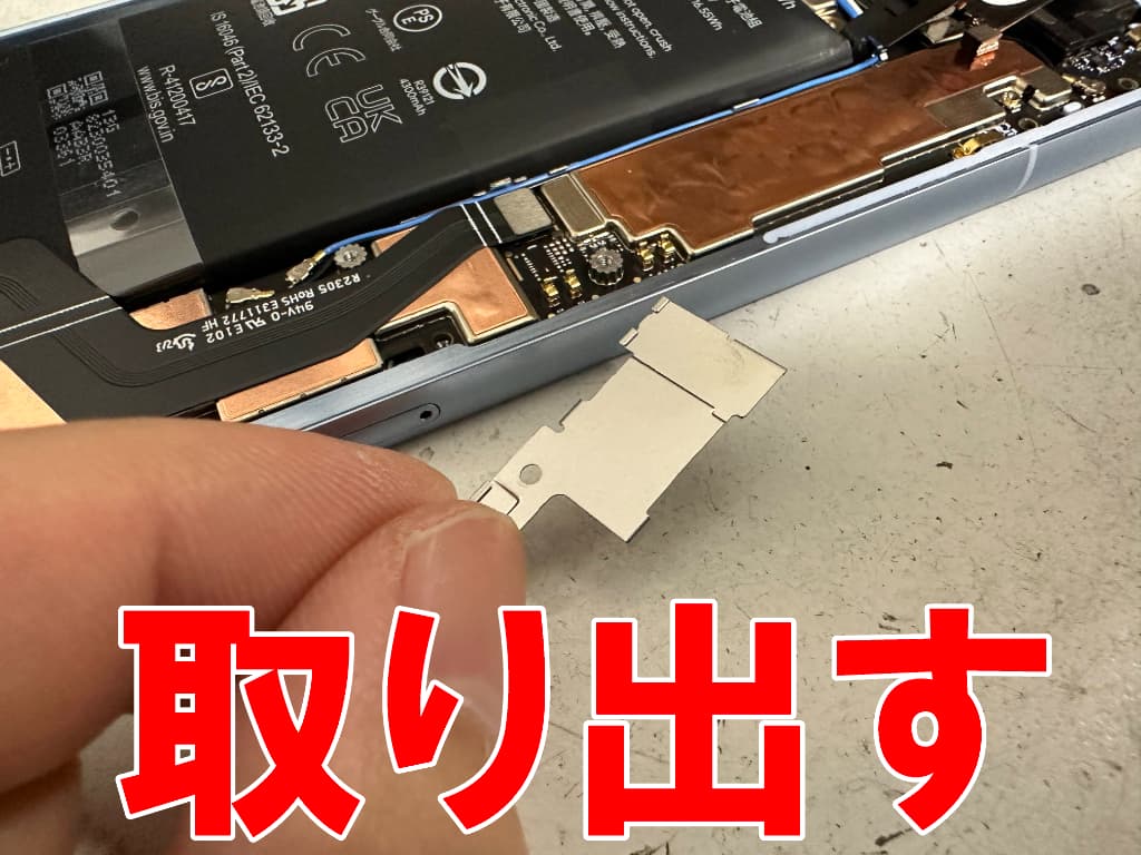 バッテリーコネクタを固定した銀板を取り出した電池パック交換中のピクセル 7a