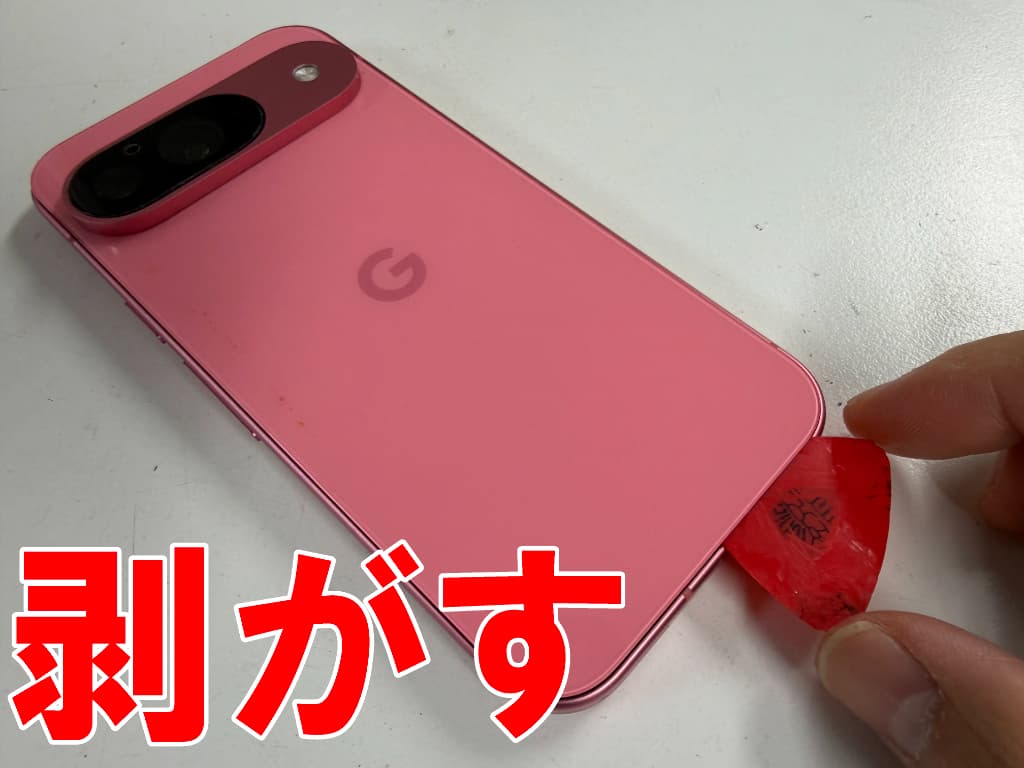 背面パネルを剥がそうとしているドックコネクタ交換修理中のピクセル9