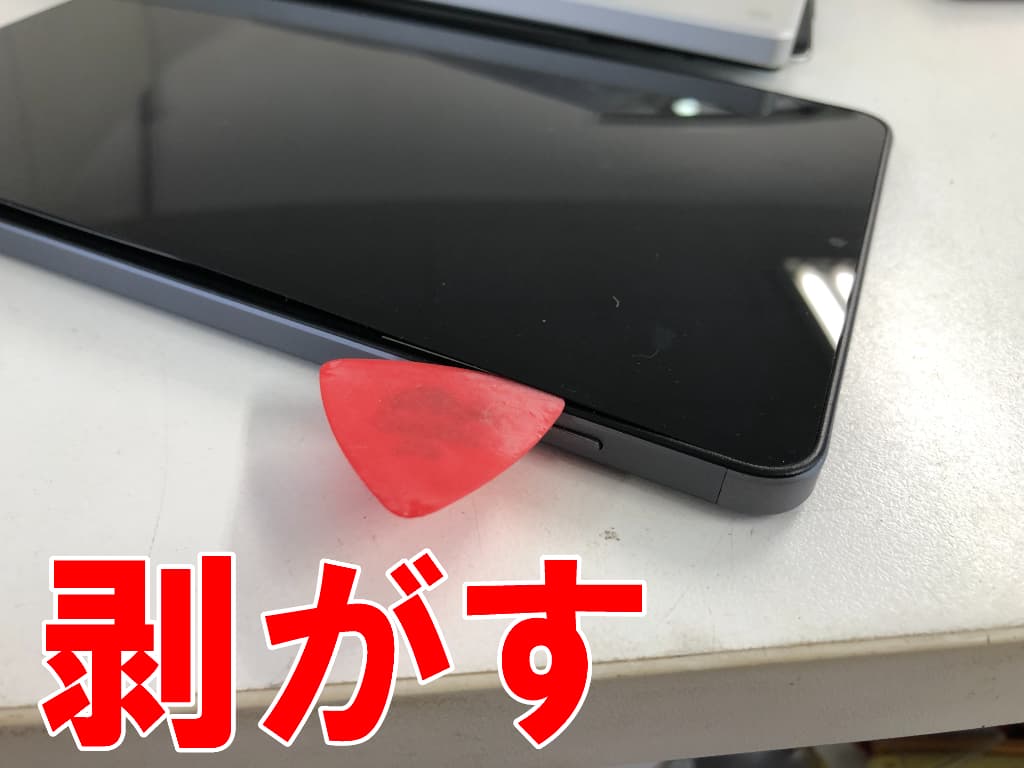 浮いた画面パーツを本体フレームから剥がして分解している電池交換修理中のiPlay60mini Pro