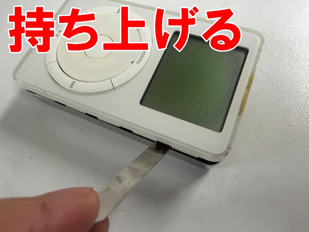 背面パネルから本体部分を持ち上げている電池パック交換修理中のiPod第1世代(M8541)