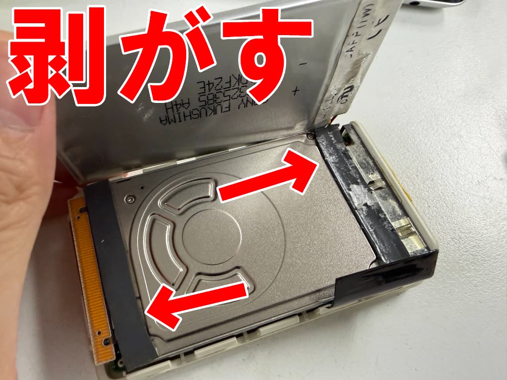バッテリーと本体部分の粘着を剥がした電池交換修理中のiPod (Scroll Wheel)