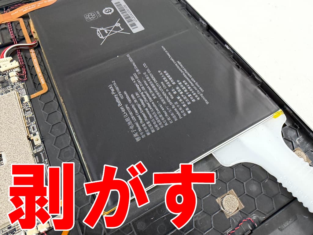 強力に接着されたバッテリーを本体フレームから剥がしているTeclast T65 Max